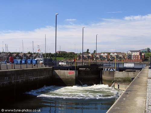 The marina entrance lock filling up to allow a boat to exit.