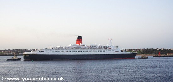 The QE2 approaching Herd Groyne with tugs at both ends.