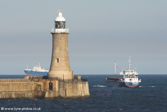 Cargo Ship Sea Box passing Tynemouth Lighthouse and Pier.