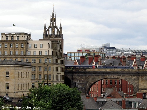 In this picture a train heads north from Newcastle Central Station, with the Cathedral Tower behaind and St James Park in the distance.