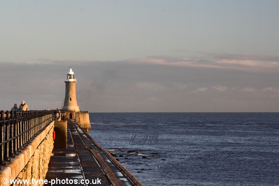 Views of the pier and lighthouse with people enjoying a walk on a fine, but cold afternoon.